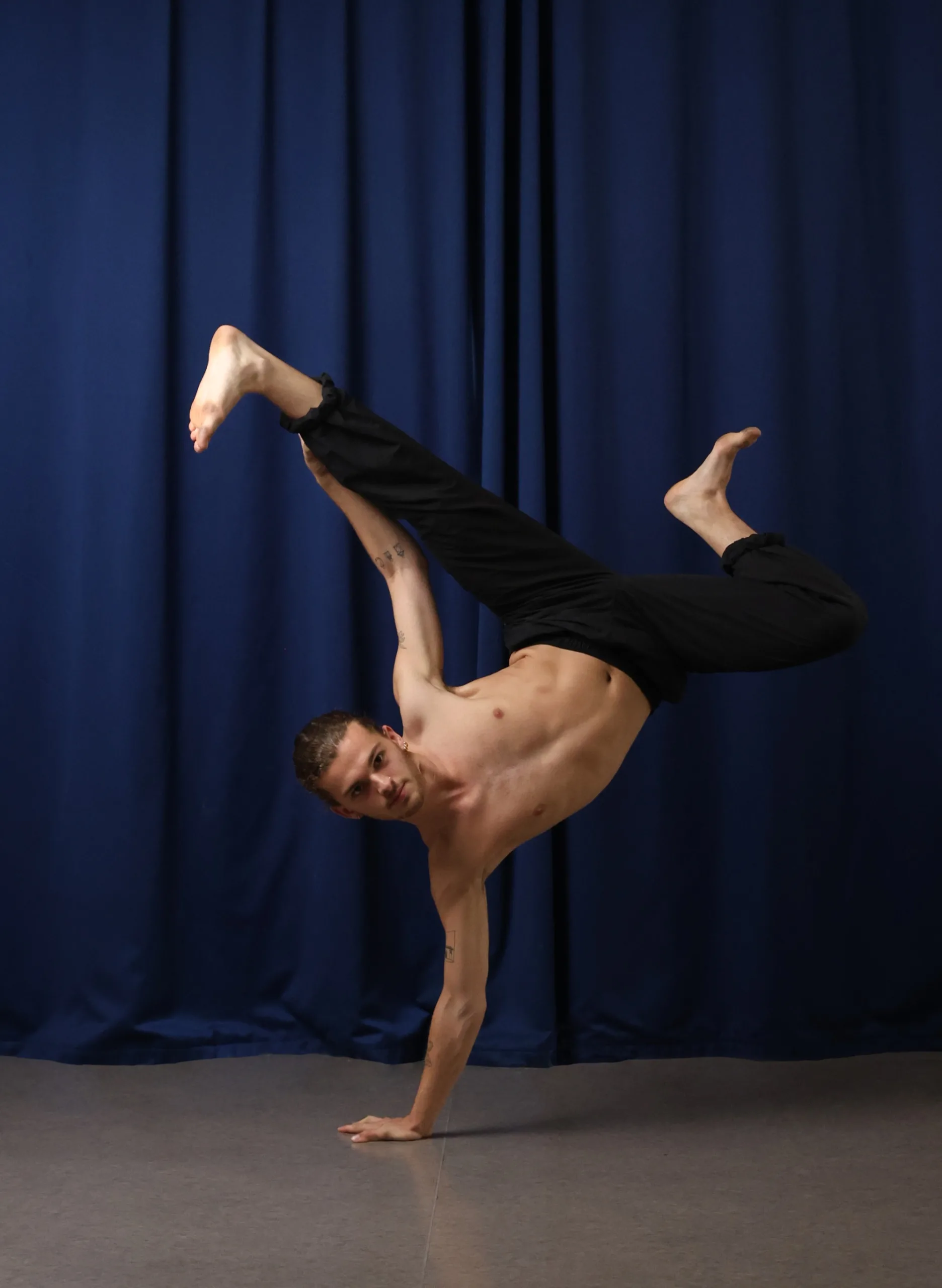 Un danseur en appui sur une main dans une recherche de mouvement