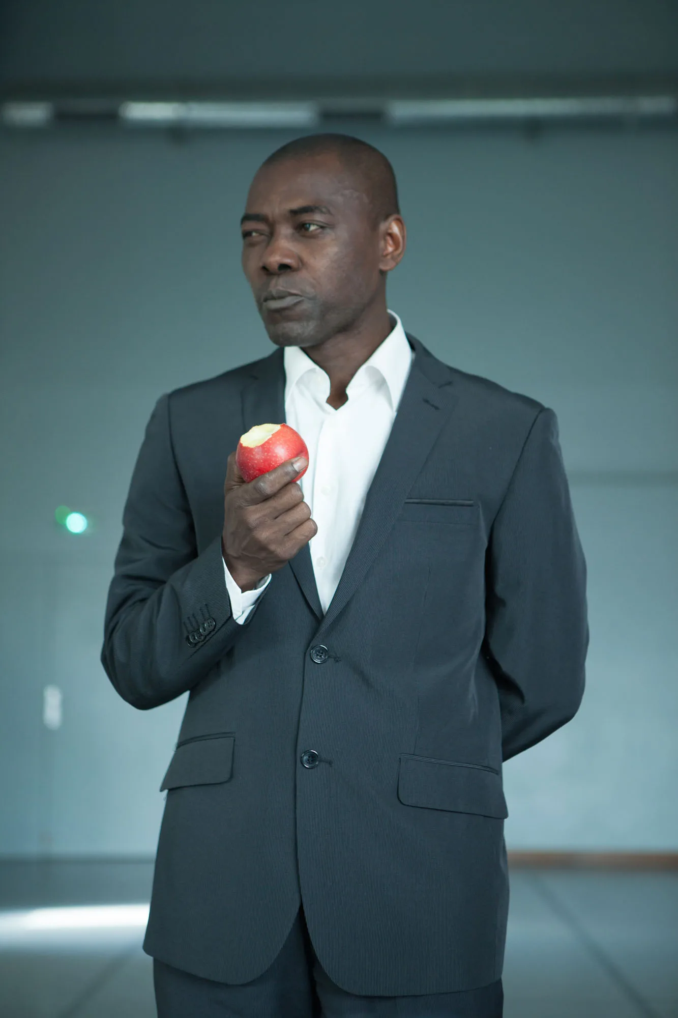 Interprète en costume sombre tenant une pomme rouge